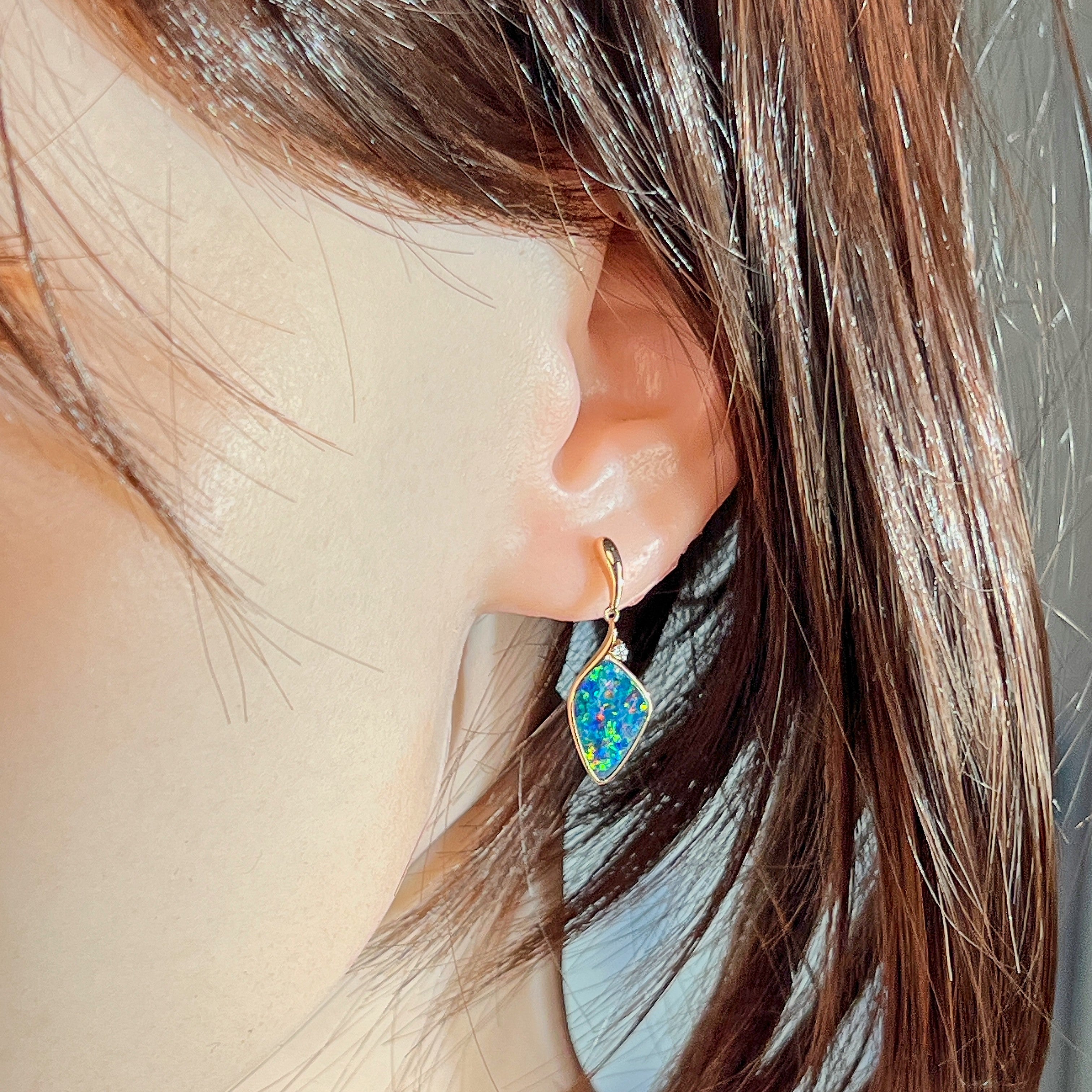 Rose gold opal doublet drop earring worn on the ear, side profile view