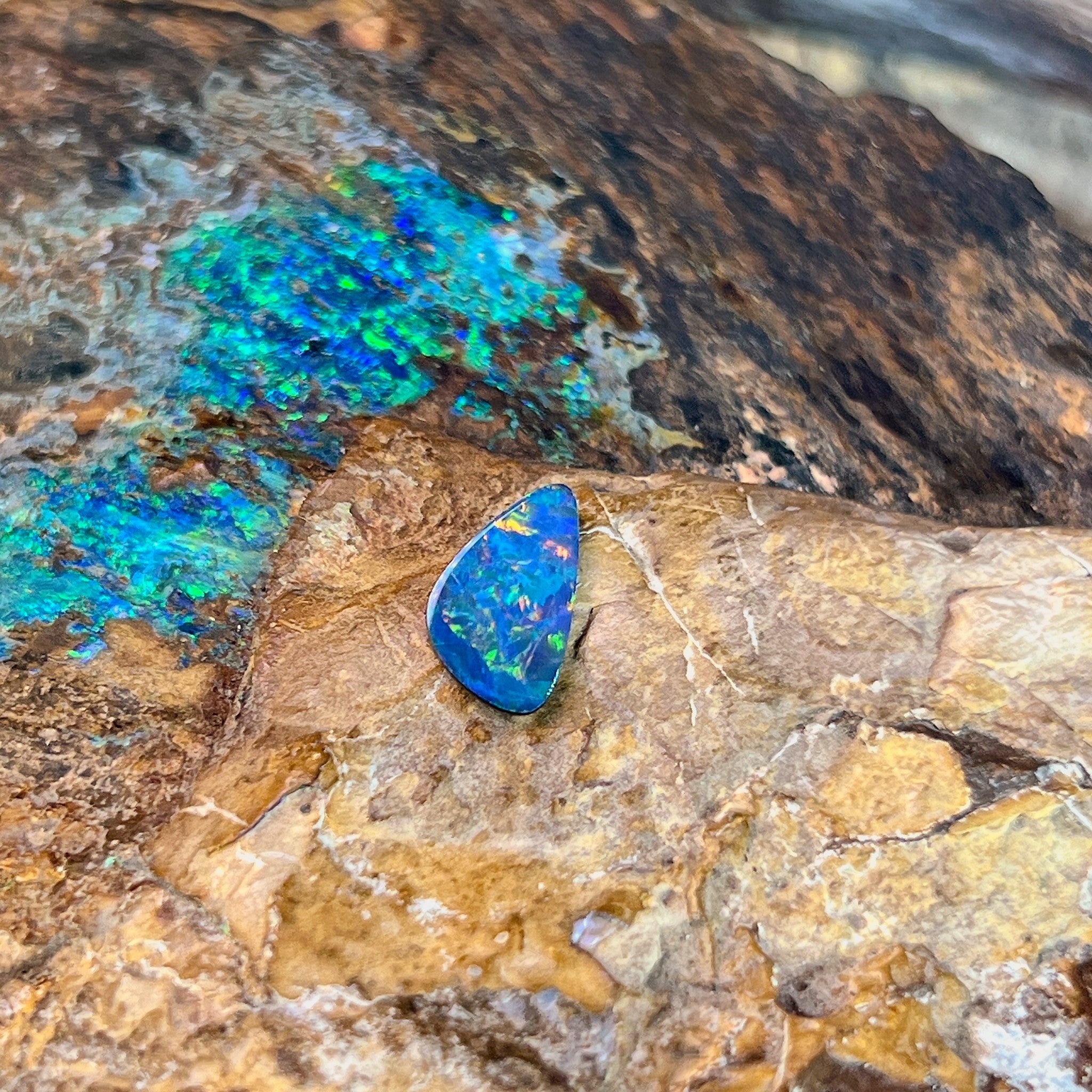 0.79ct Australian opal doublet on ironstone, a blue body scattered with green and gold