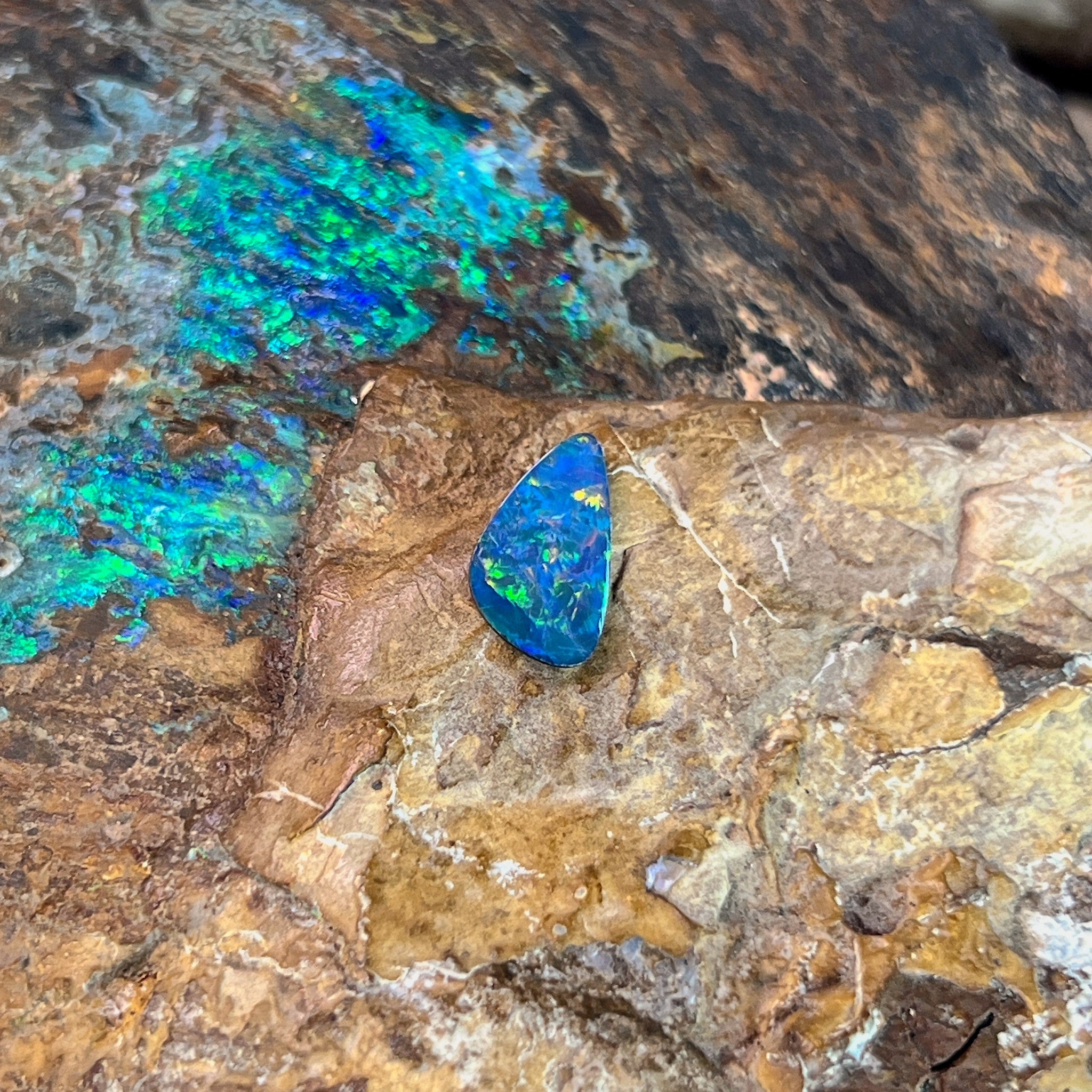 Green and yellow sparks across a blue 0.79ct Australian opal doublet, 11x6.4mm