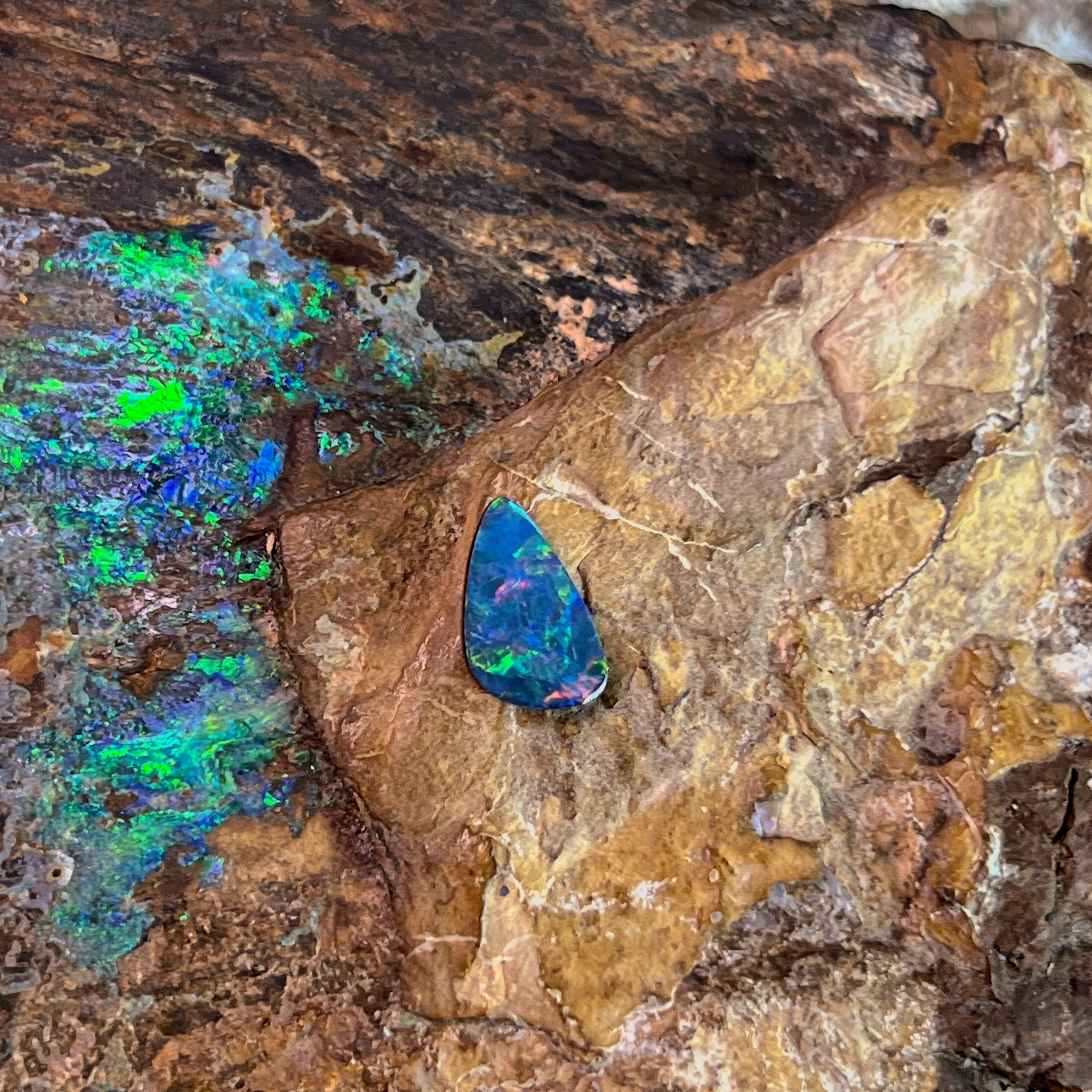 0.79ct Australian opal doublet showing green and rose flashes against weathered ironstone