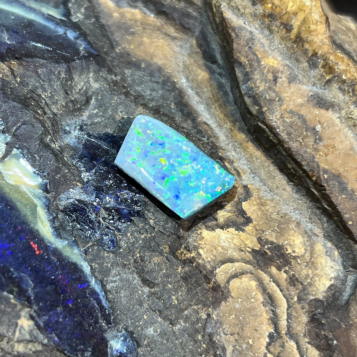 Solid Australian black opal 5.15ct, rectangular 16.8x10.3mm, yellow, orange and green with blue pinfire, loose stone on rock