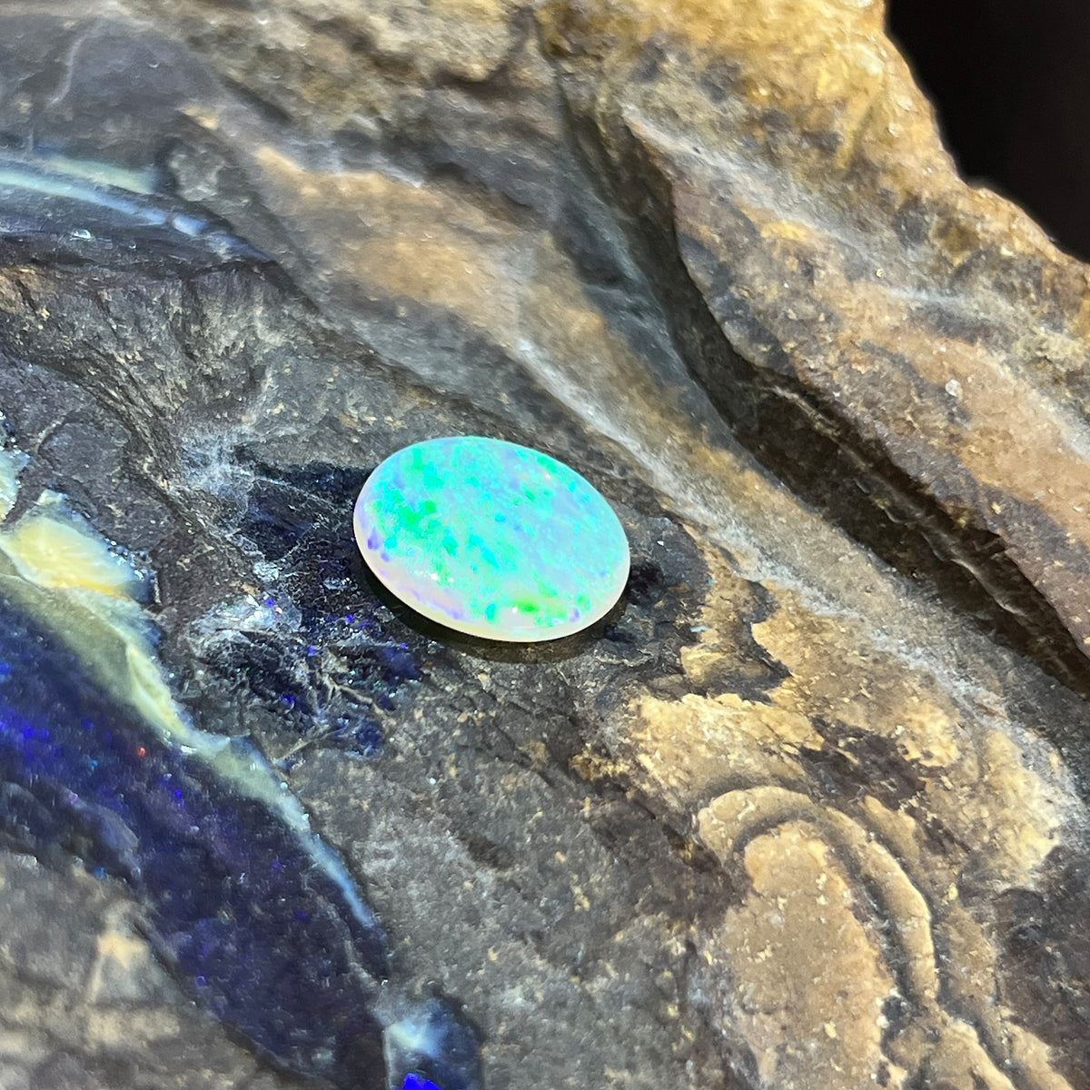 Australian crystal opal 3.25ct round cabochon, 12.6mm, yellow and green with a hint of blue, loose and unset, on rock