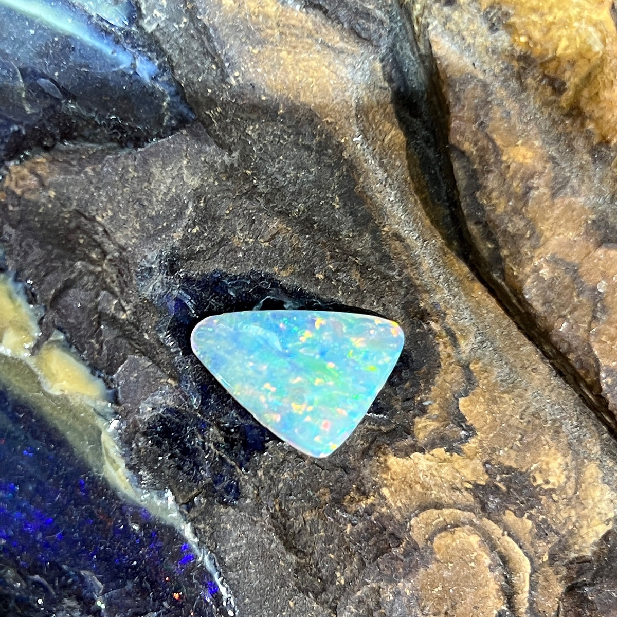 Loose solid crystal opal 2.15ct, triangular, yellow, orange, green and blue, ready for a custom setting, on rock
