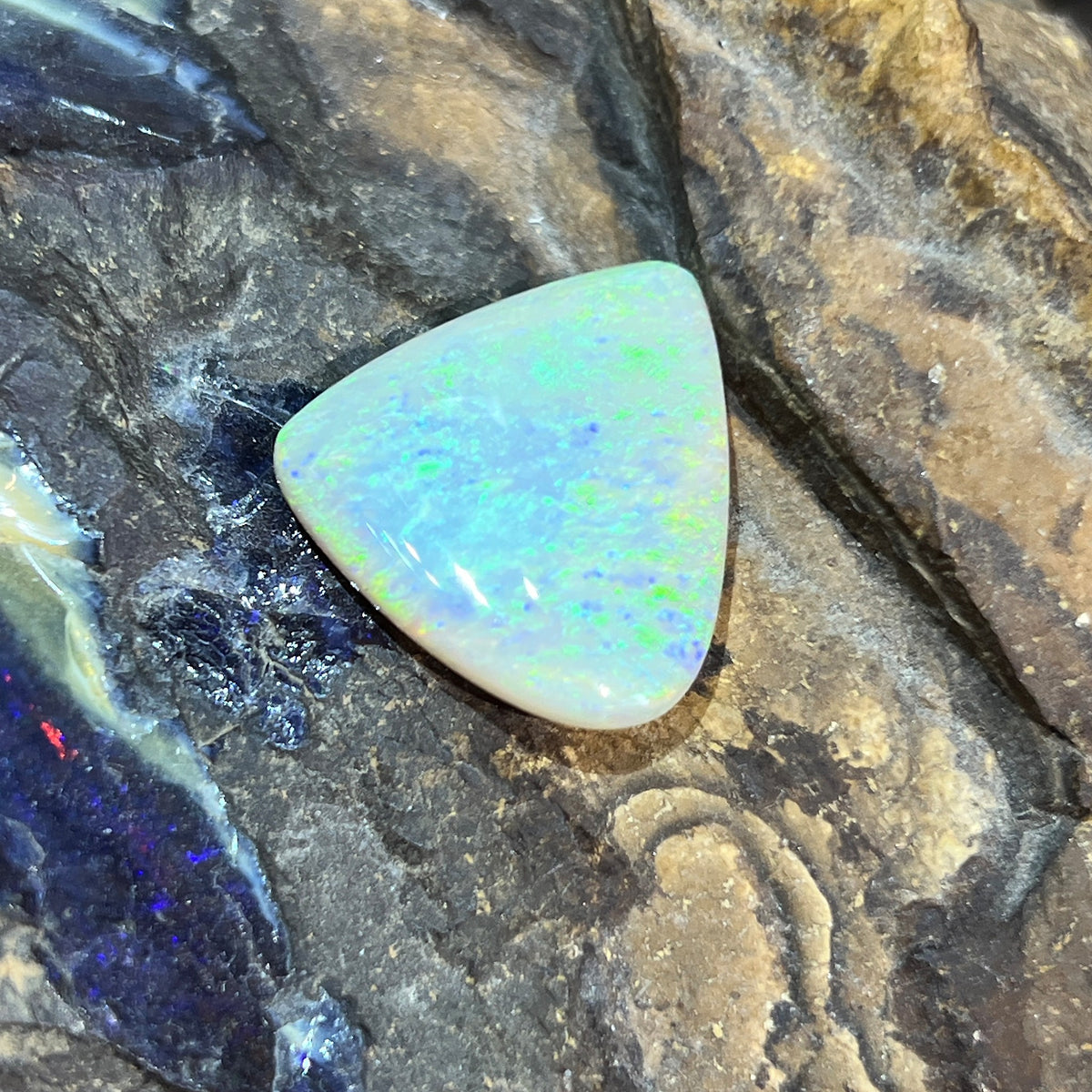 Solid Australian crystal opal 16.50ct, triangular 23.2x20.7mm, yellow and green with a hint of blue stripe, loose stone on rock