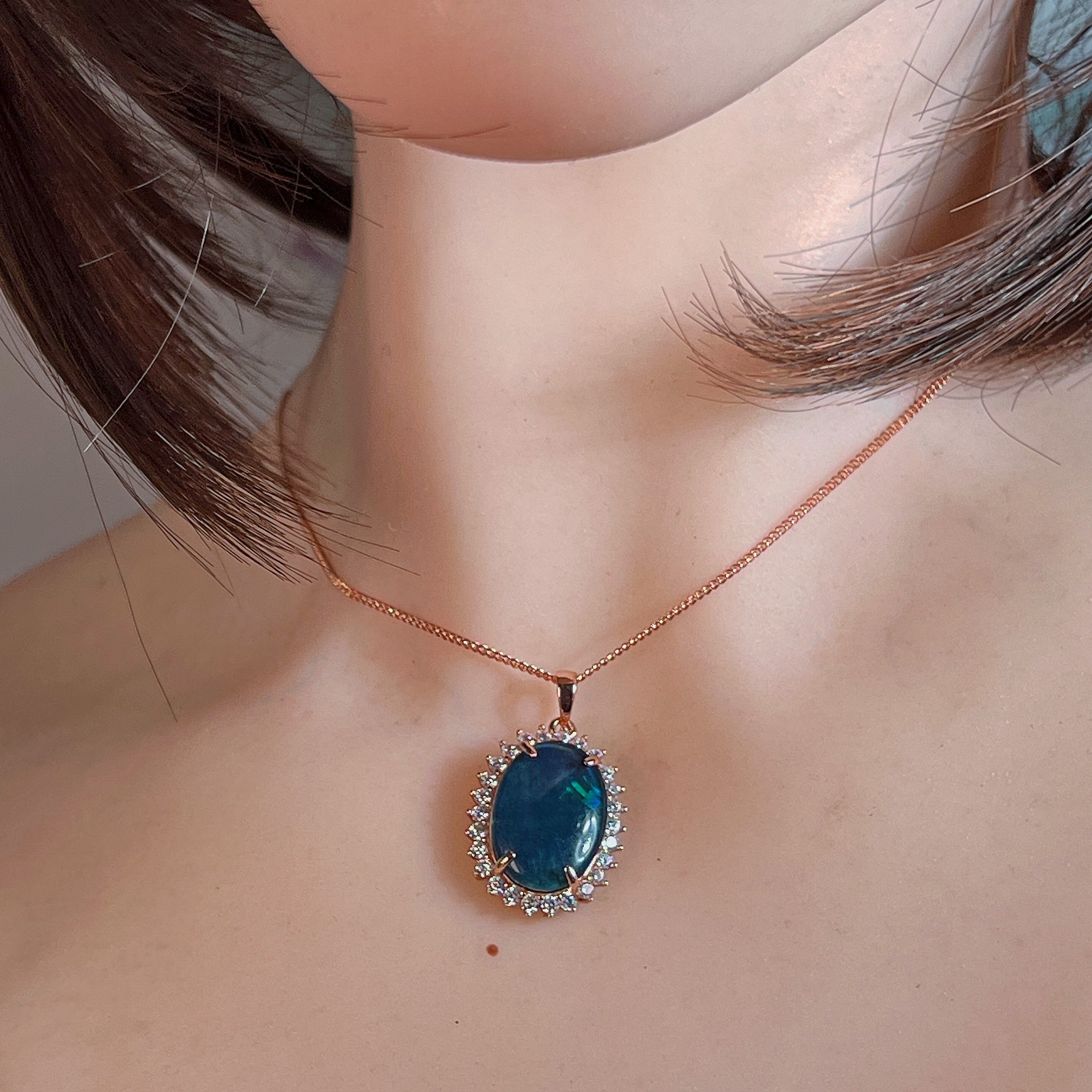 18x13mm opal triplet halo pendant worn at the neck, showing its scale on the collarbone