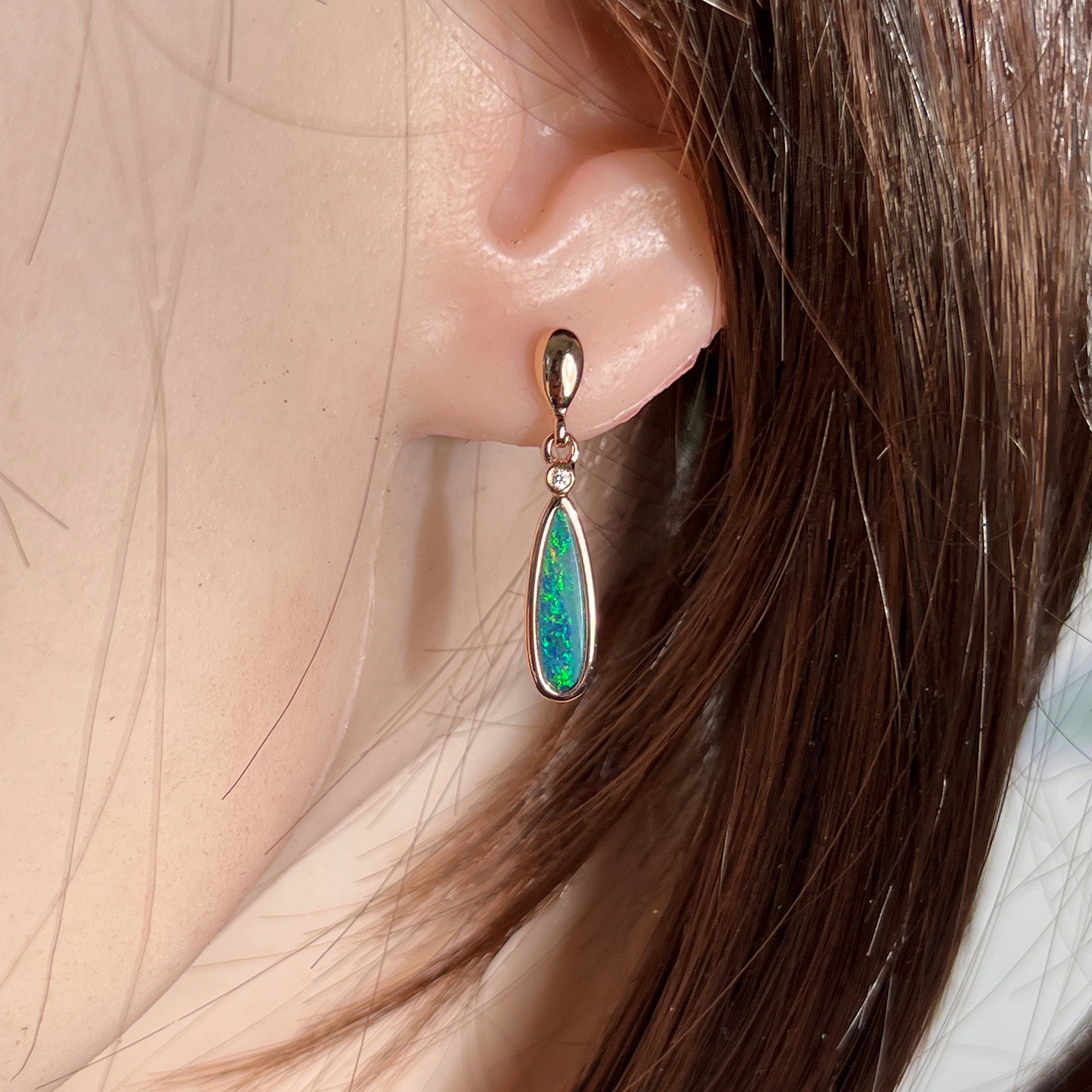 pear-shaped Australian opal doublet earrings in rose gold-plated silver, worn on the ear