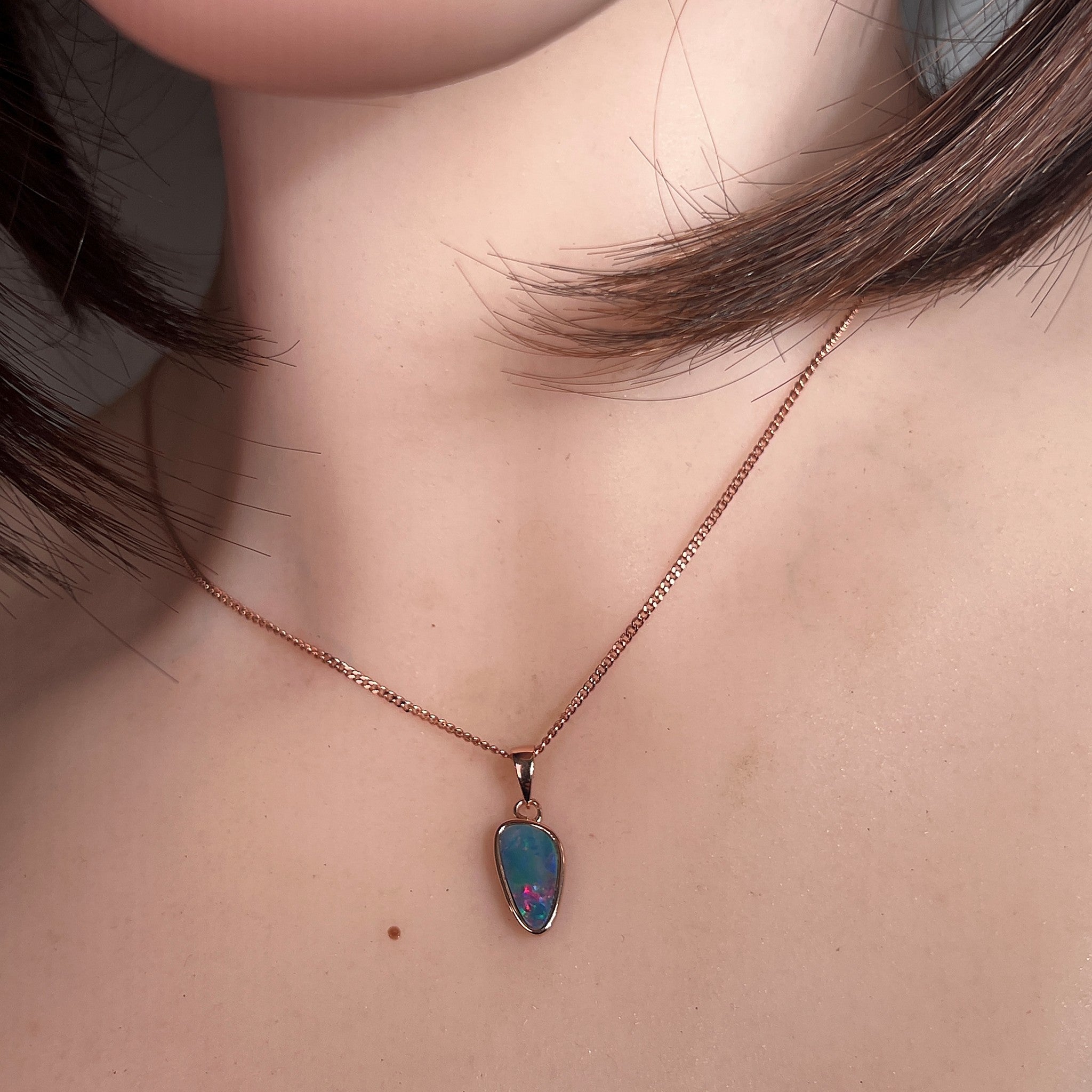 Australian opal doublet pendant worn at the neck, red, green and blue play-of-colour