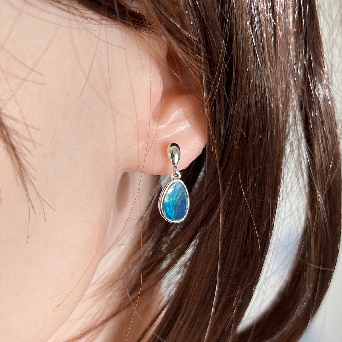 freeform Australian opal doublet earrings in sterling silver, worn on the ear