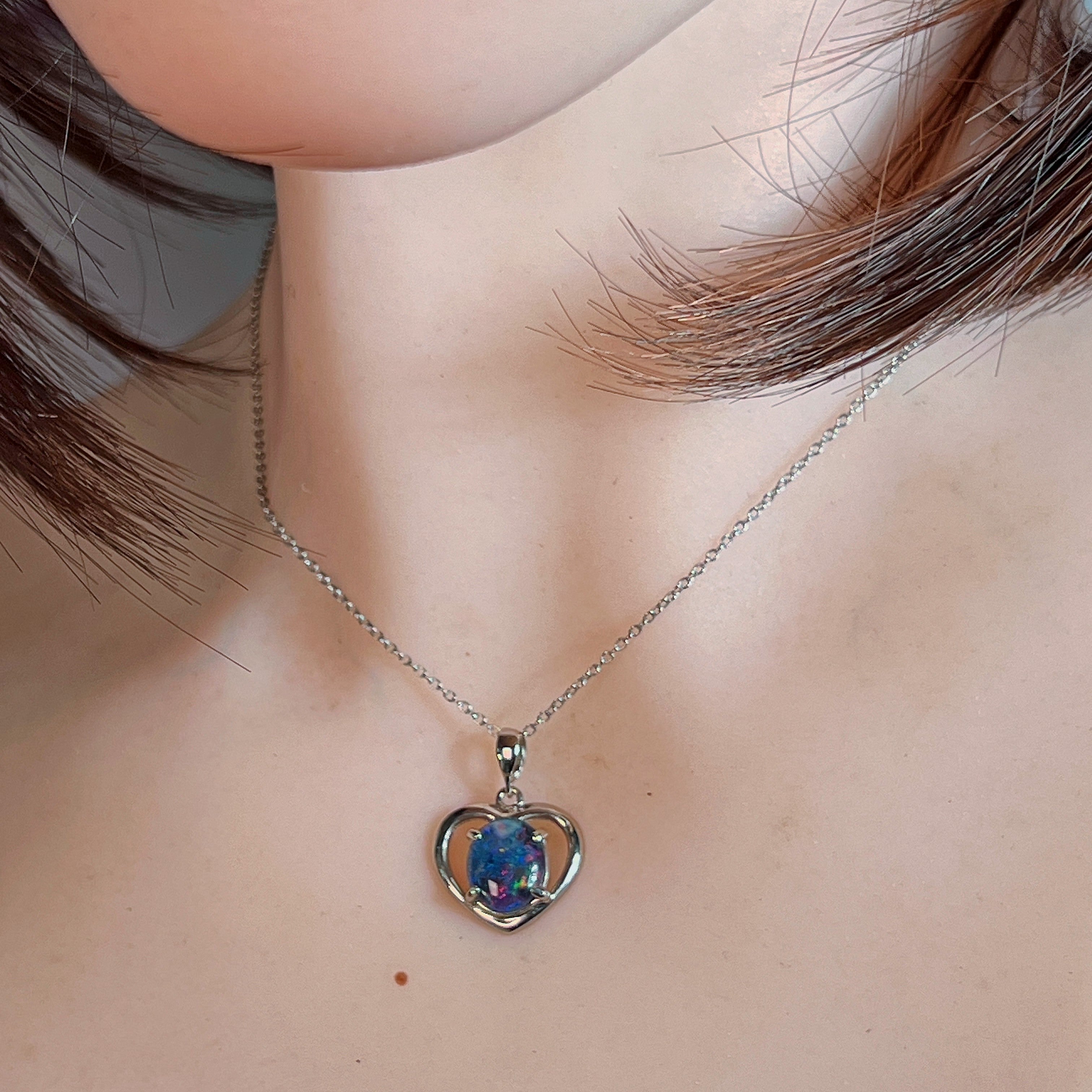 Silver heart opal triplet pendant worn at the neckline, close view