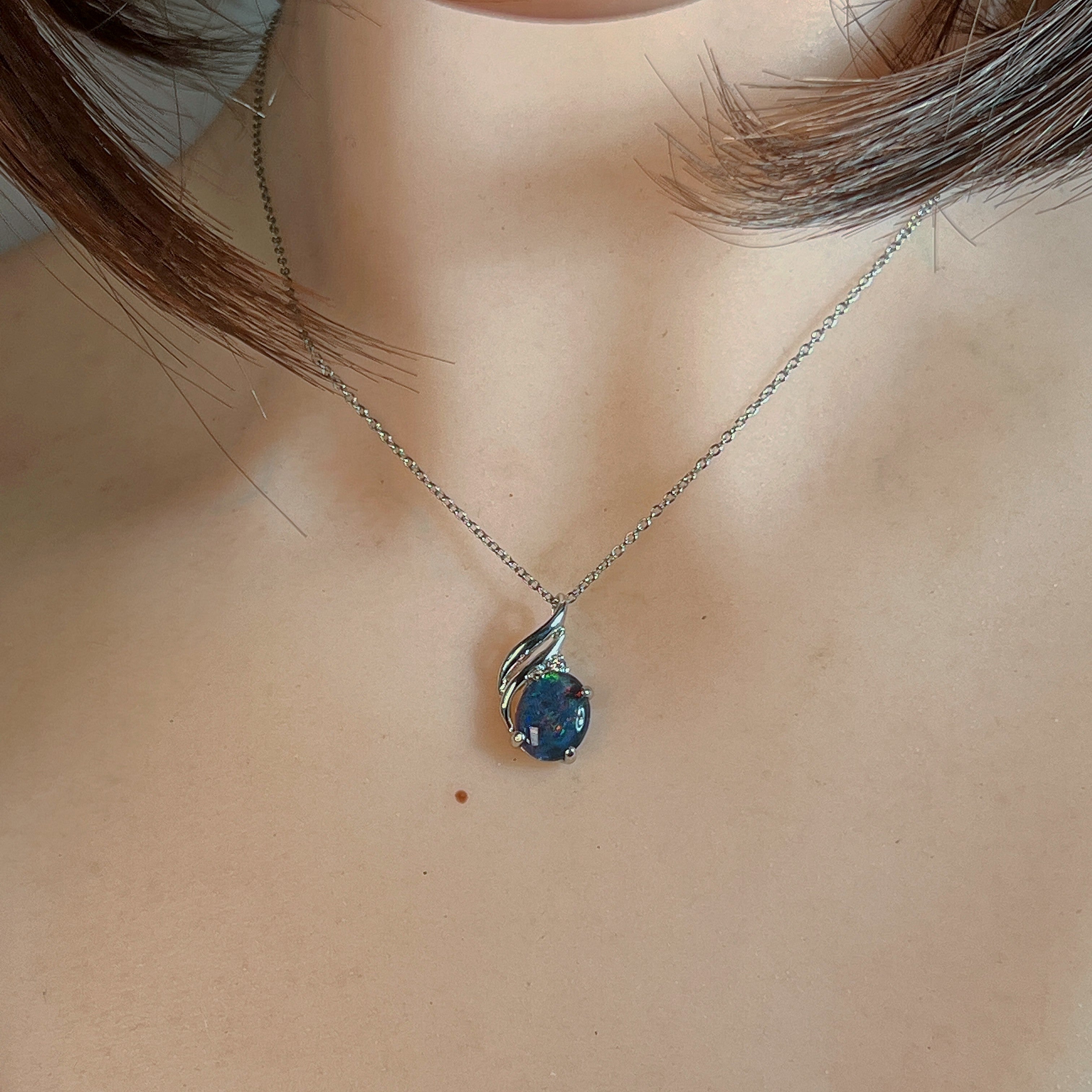 Sterling silver opal triplet pendant worn at the neck on a fine chain