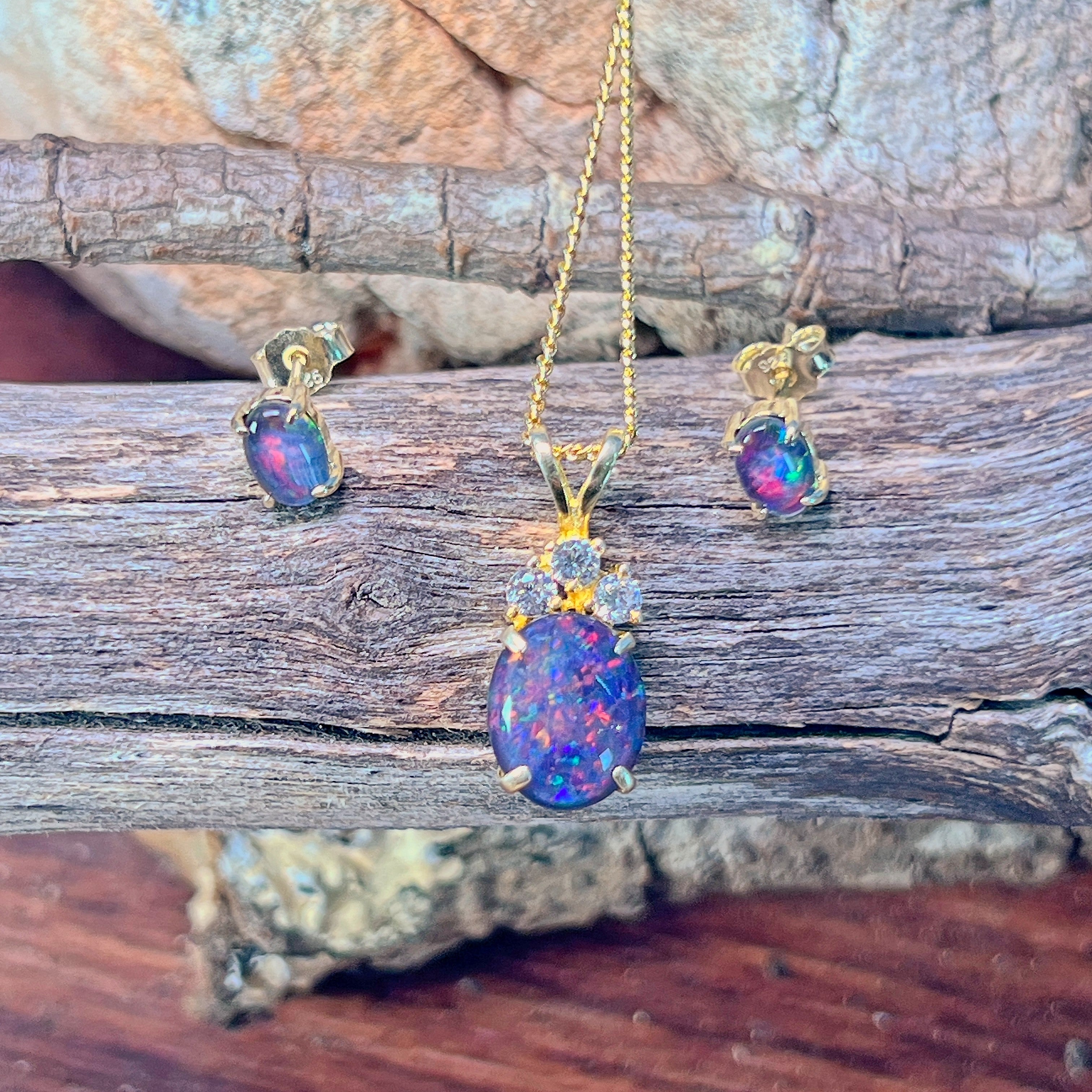 Oval opal triplet pendant with accent stones showing blue and red play-of-colour