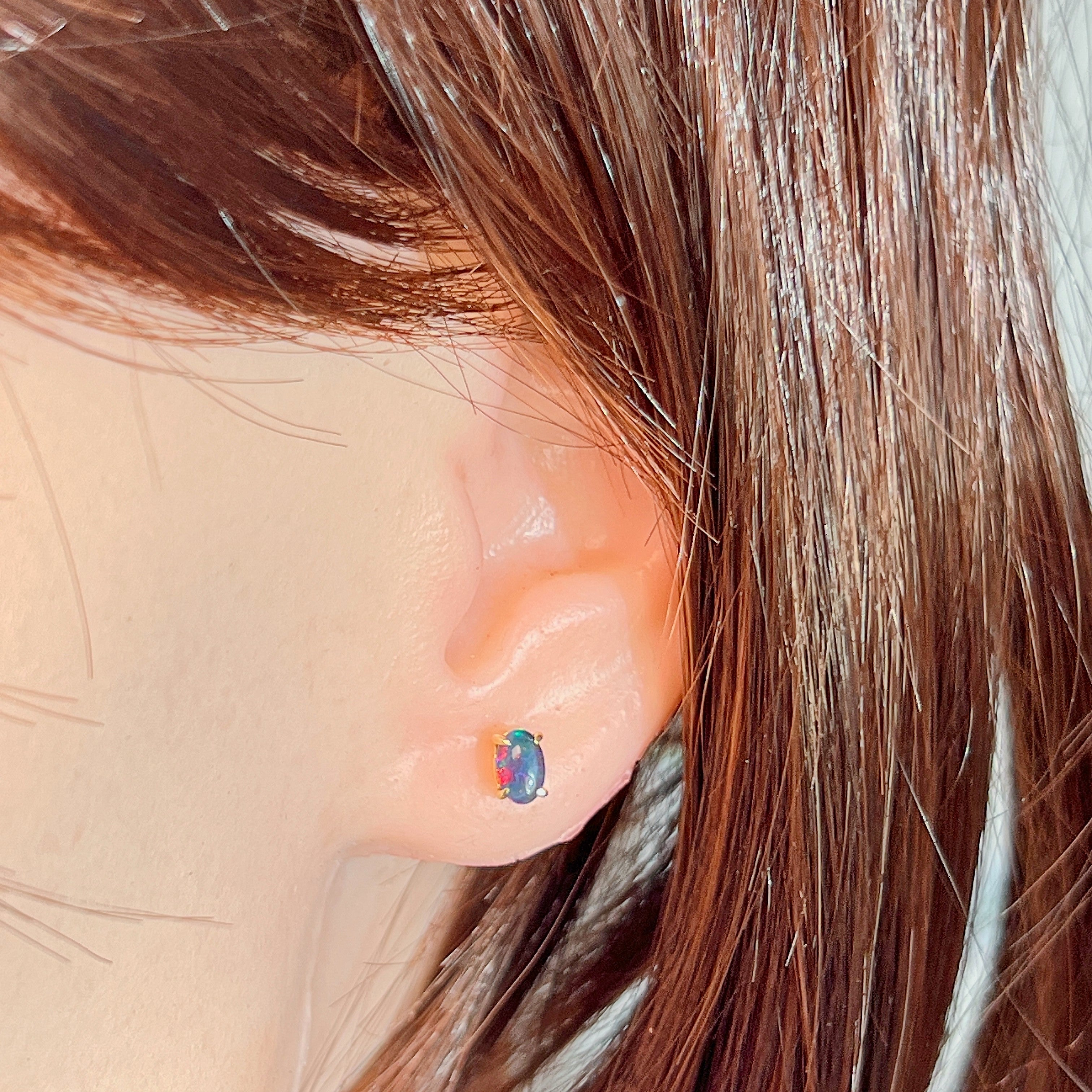6x4mm opal triplet stud earring worn on the ear, showing its scale on the earlobe