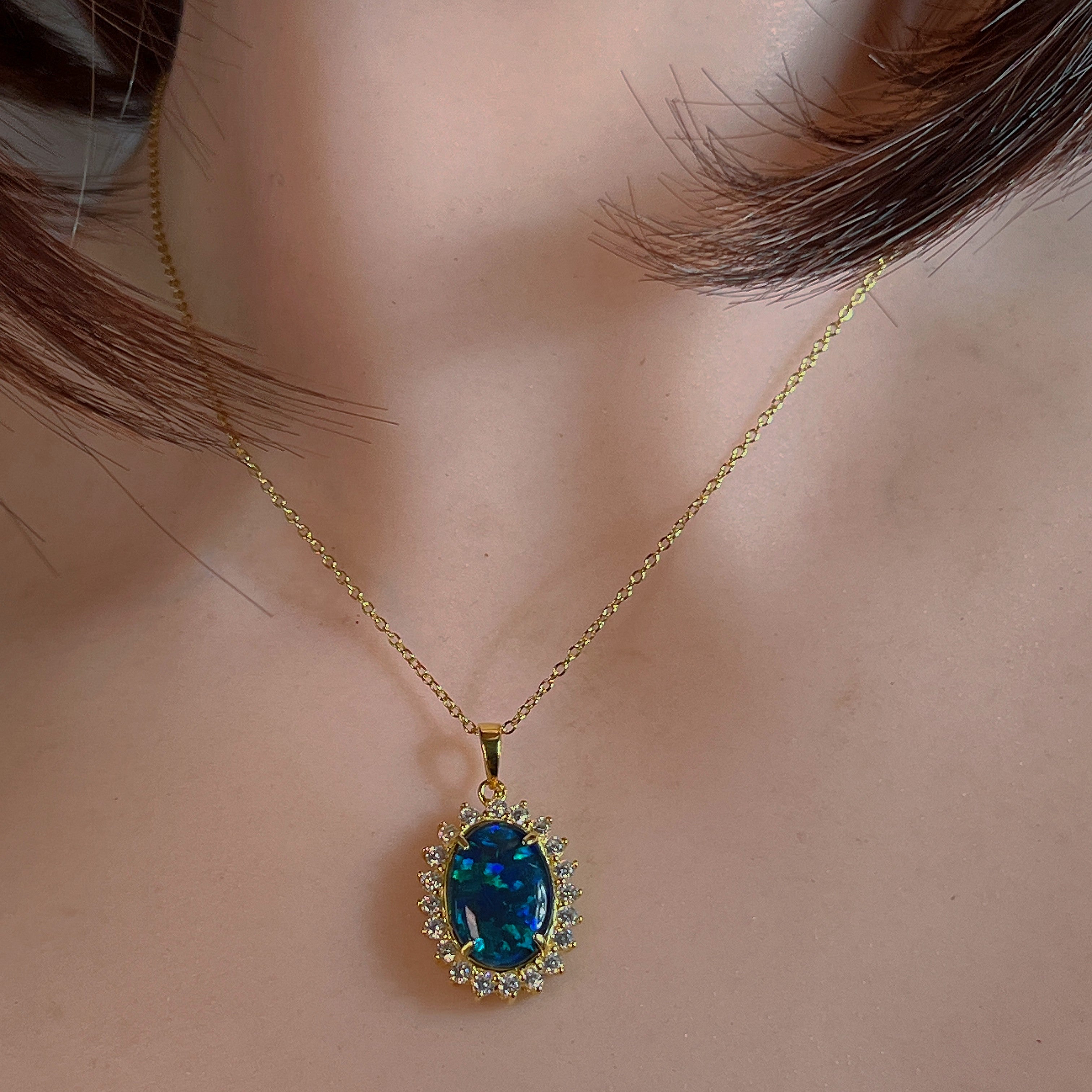 Opal triplet halo pendant worn at the neck on a fine gold-plated chain