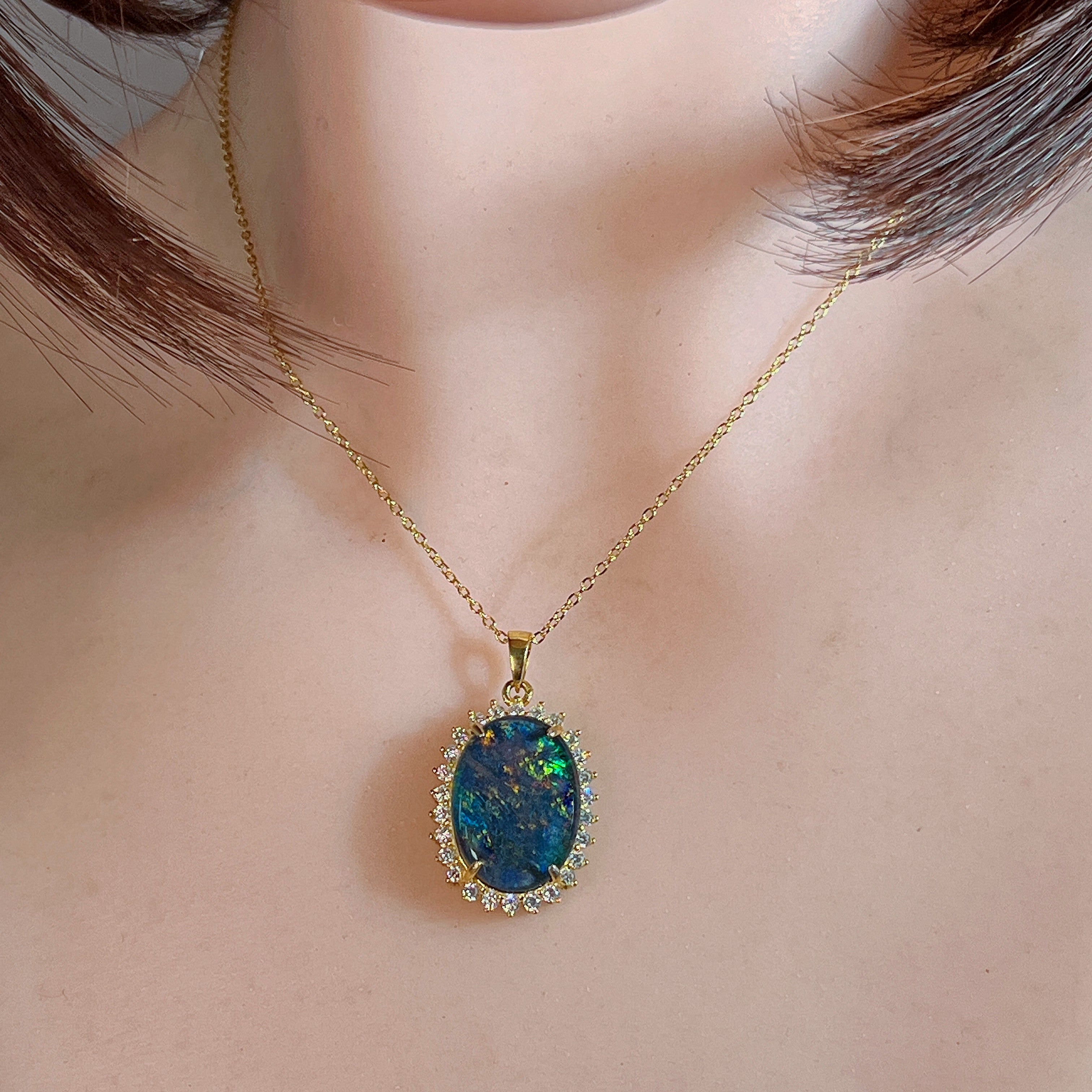 Opal triplet halo pendant worn at the neck, showing its scale on the collarbone