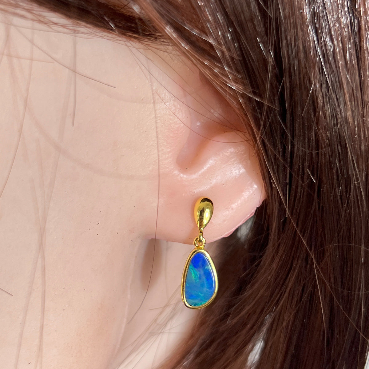 freeform Australian opal doublet earrings in yellow gold-plated silver, worn on the ear