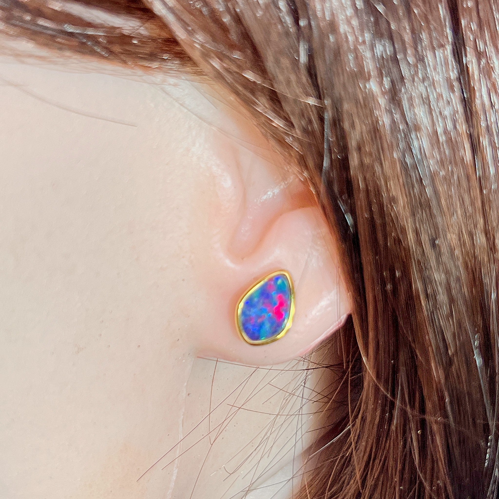 Worn Australian opal doublet earrings in yellow gold-plated silver, red, blue and green, 11 x 7.5mm