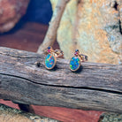 14kt rose gold opal doublet stud earrings showing blue and pink flash across the ovals