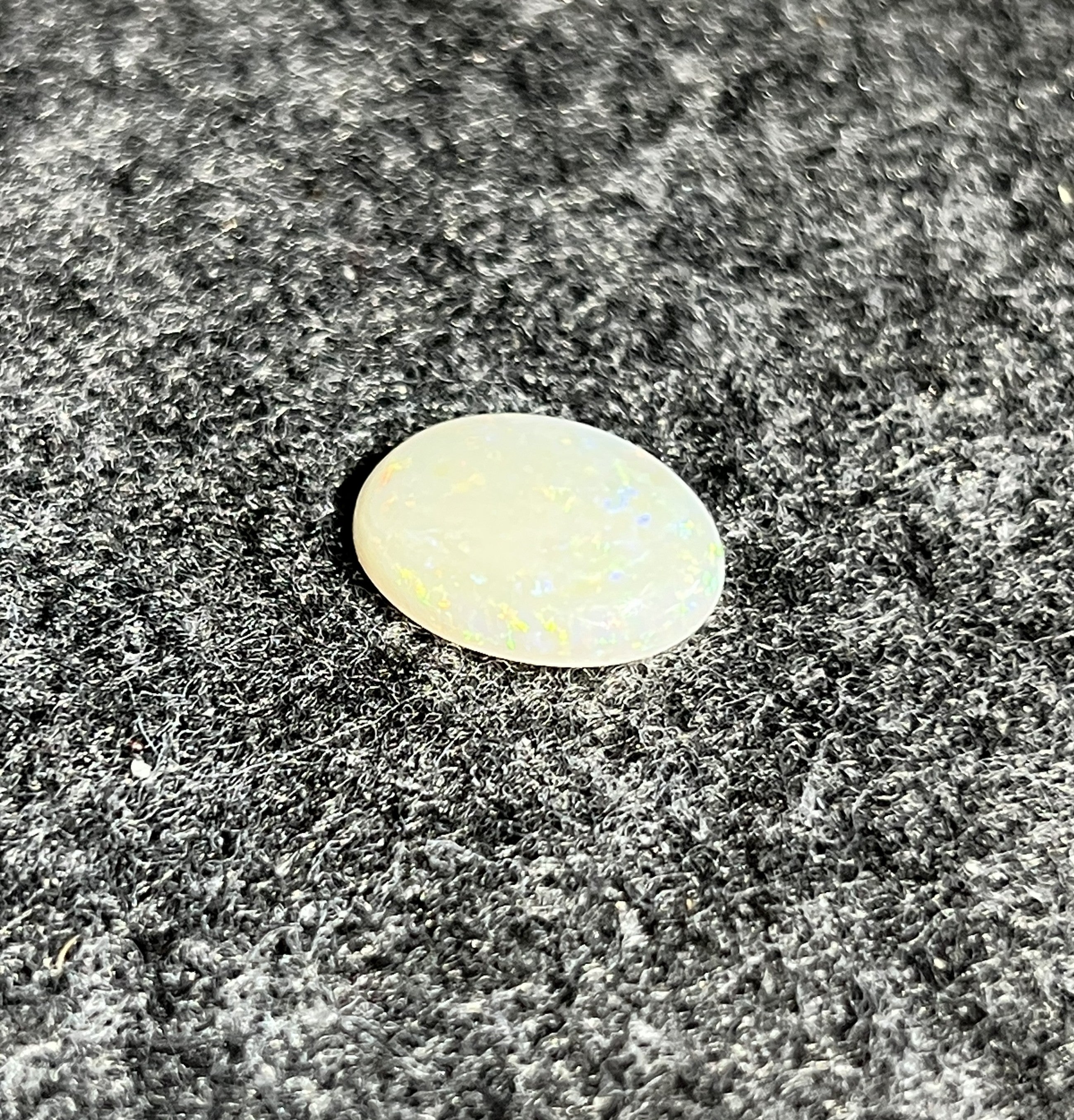Natural Australian white opal, 4.89ct oval cabochon 16x12mm, with soft pastel play-of-colour