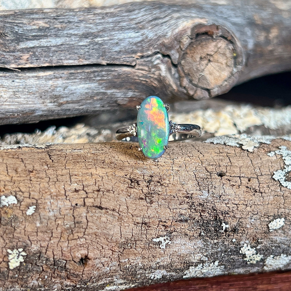 Genuine Australian black opal ring in 18kt white gold, oval stone with red, green and yellow colour