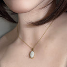 Australian white opal pendant worn, 2.3ct oval white opal claw set in 18kt yellow gold