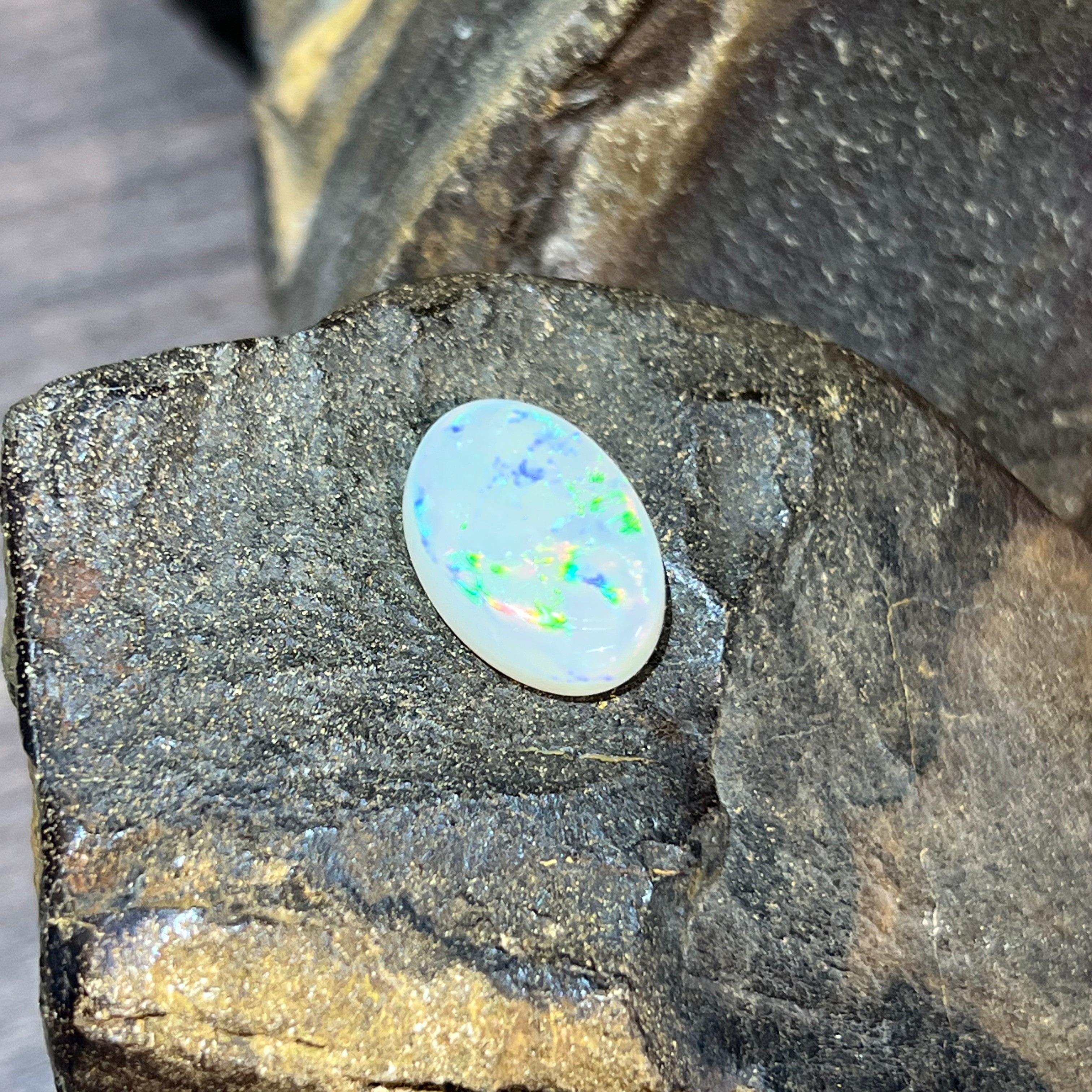 White opal 5.56ct showing dense emerald-green pinfire play-of-colour