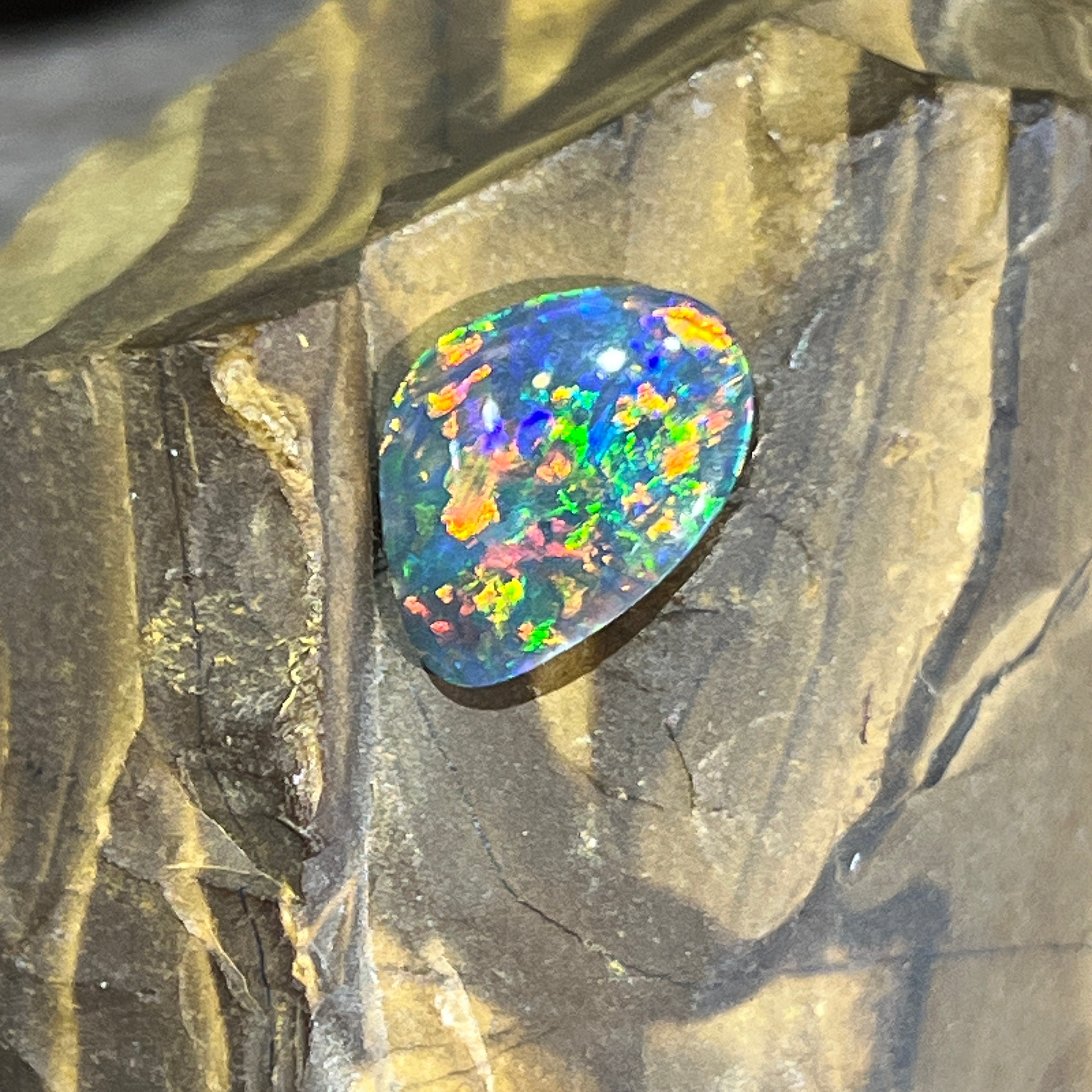 Australian black opal, 1.78ct freeform, dense red, orange, green and blue play of colour