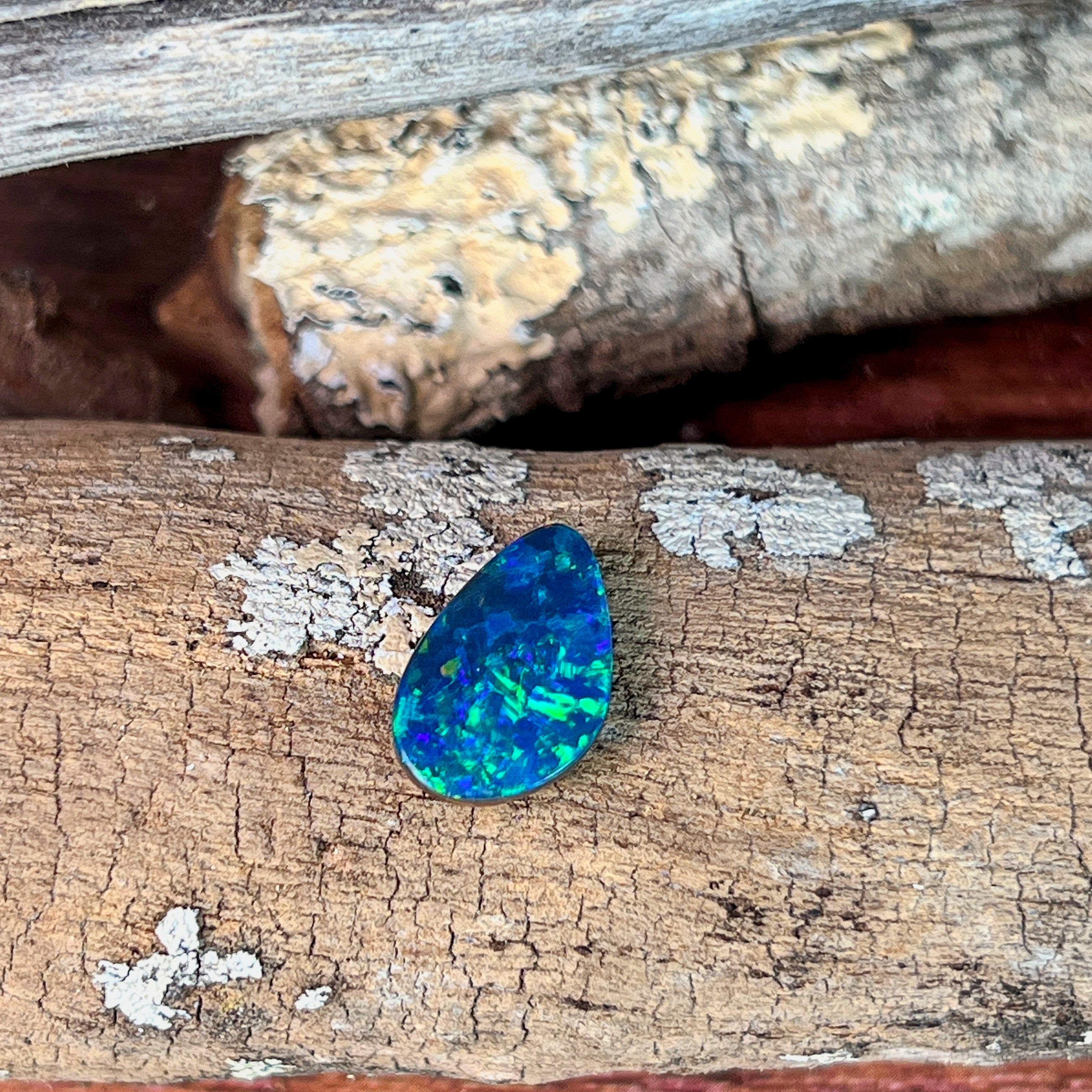 Top view of the 15.5x10mm pear shaped opal doublet showing blue and green play-of-colour