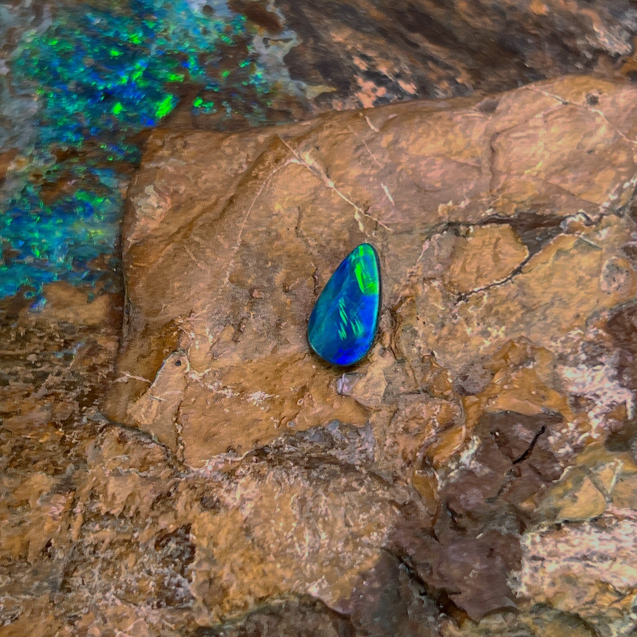 Green and yellow flash across a 0.82ct pear shape Australian opal doublet, 10.2x5.7mm