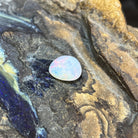 Australian white opal 3.60ct freeform cabochon, 12.2x12mm, blue and green with red flashes, loose and unset, on rock