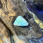 2.15ct triangular crystal opal loose stone, yellow, orange, green and blue play-of-colour, unset, on rock