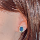 Rose gold-plated opal triplet halo stud earring worn on the ear, showing its scale