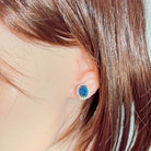10x8mm opal triplet halo stud worn on the ear beneath loose hair