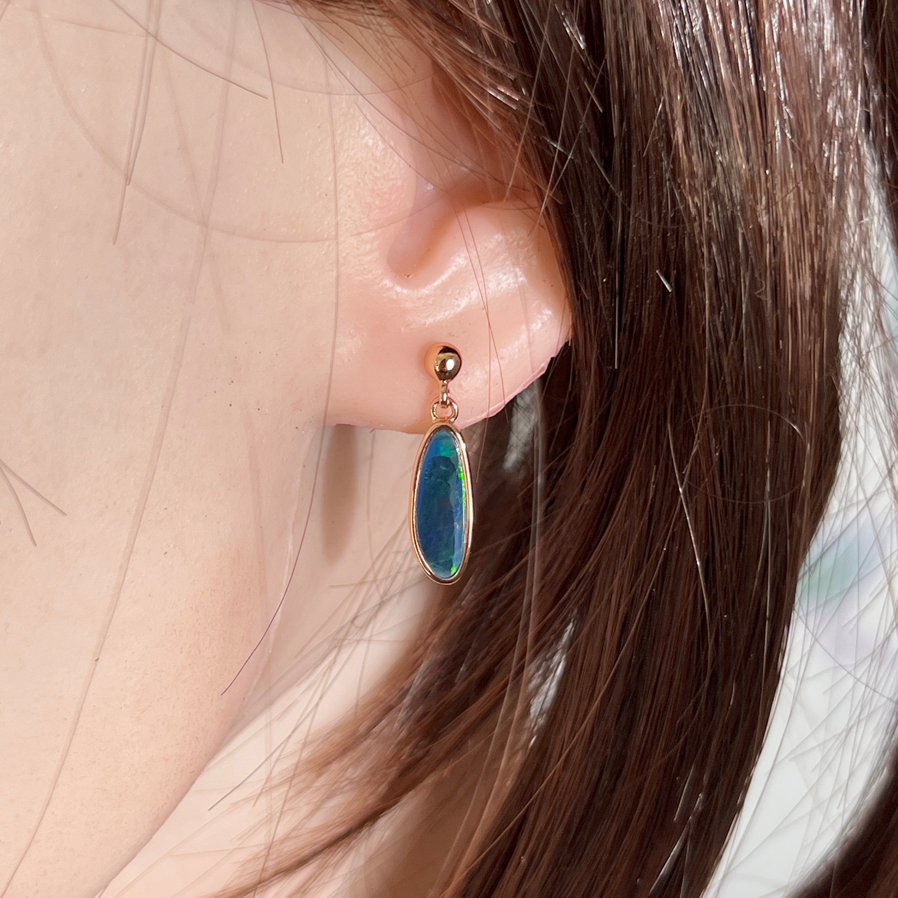 freeform Australian opal doublet earrings in rose gold-plated silver, worn on the ear