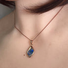 Worn Australian opal doublet pendant in rose gold-plated silver, red, blue and green, 12 x 9mm