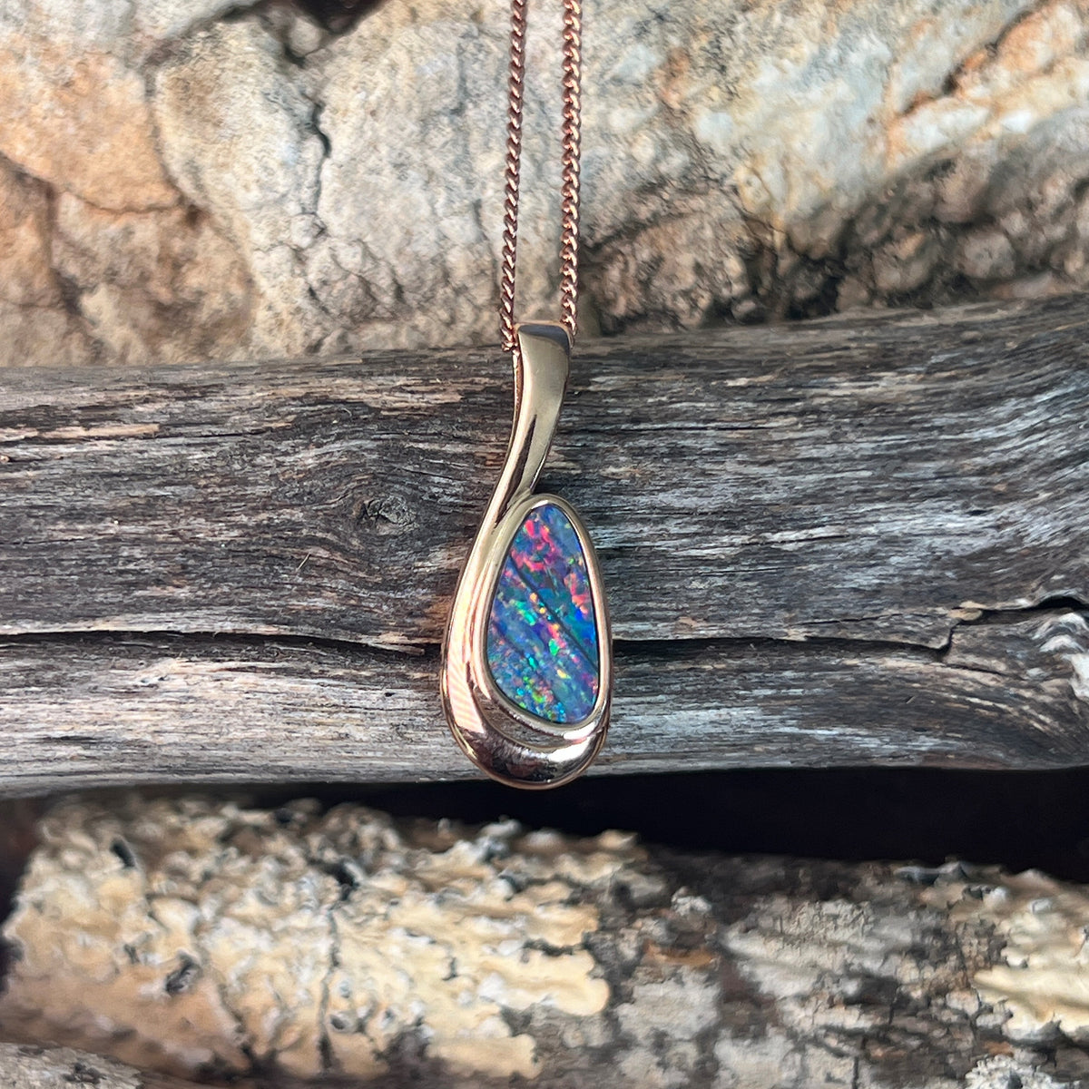 red, blue and green play-of-colour in a 12 x 7mm freeform Australian opal doublet pendant