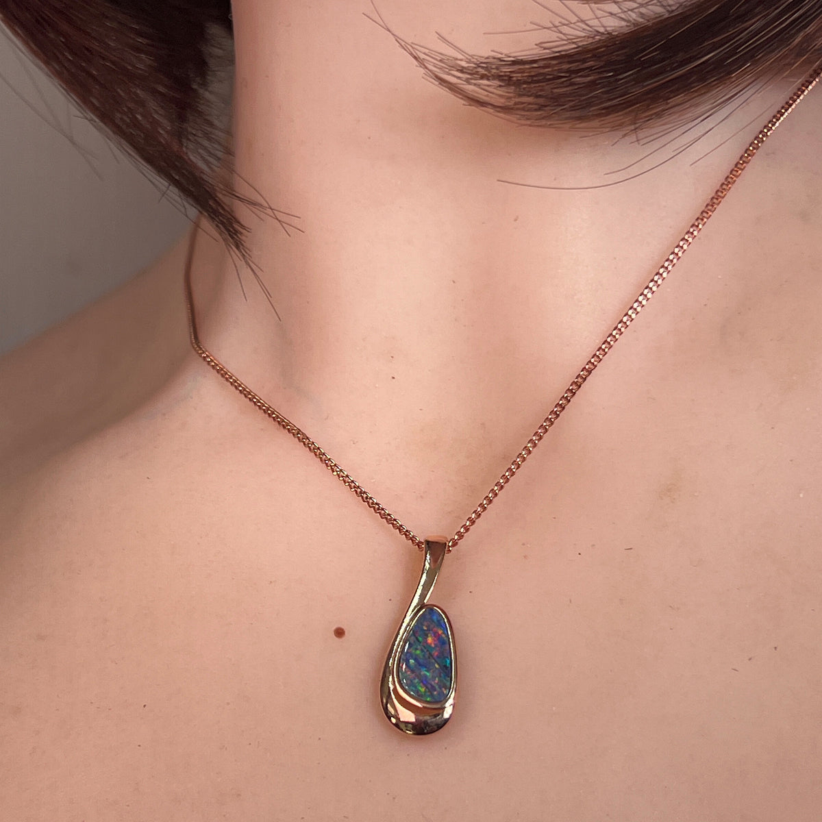 Australian opal doublet pendant worn at the neck, rose gold-plated silver, 12 x 7mm freeform stone
