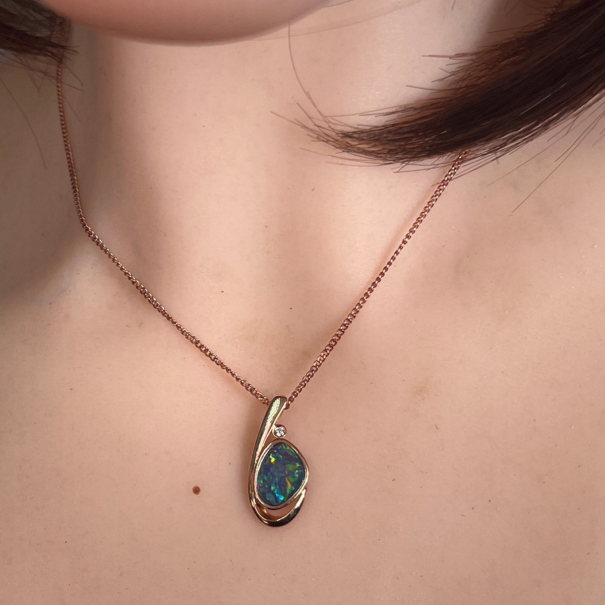 Australian opal doublet pendant worn at the neck, green, red and blue play-of-colour