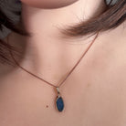 Australian opal doublet pendant worn at the neck, red, blue, orange and green play-of-colour