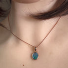 oval Australian opal doublet pendant in rose gold-plated silver, worn at the neck