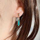 Australian opal doublet earrings worn on the ear, green and blue play-of-colour