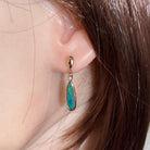 16 x 5mm pear-shaped Australian opal doublet earrings worn on the ear, rose gold-plated silver