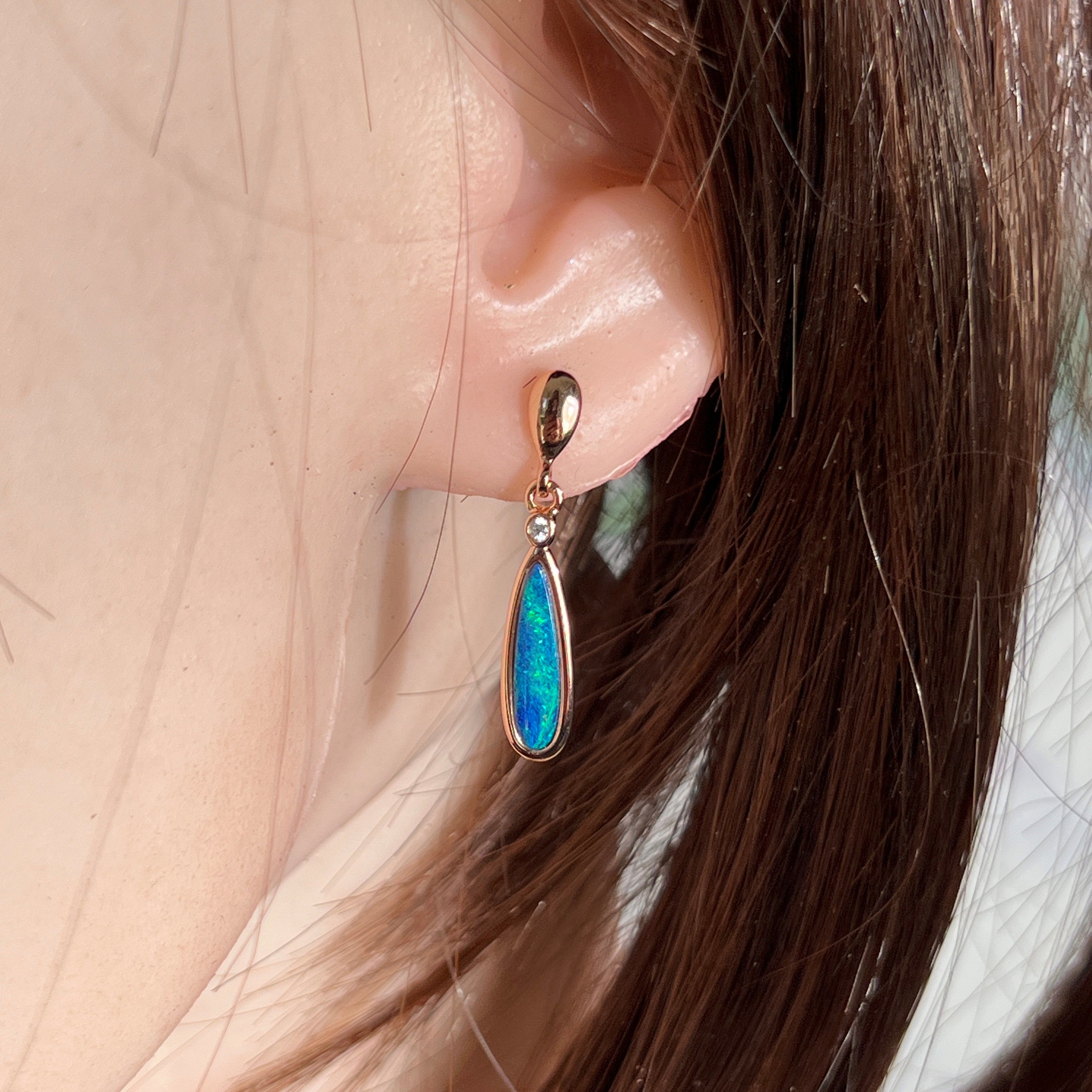 15 x 5mm pear-shaped Australian opal doublet earrings worn on the ear, rose gold-plated silver