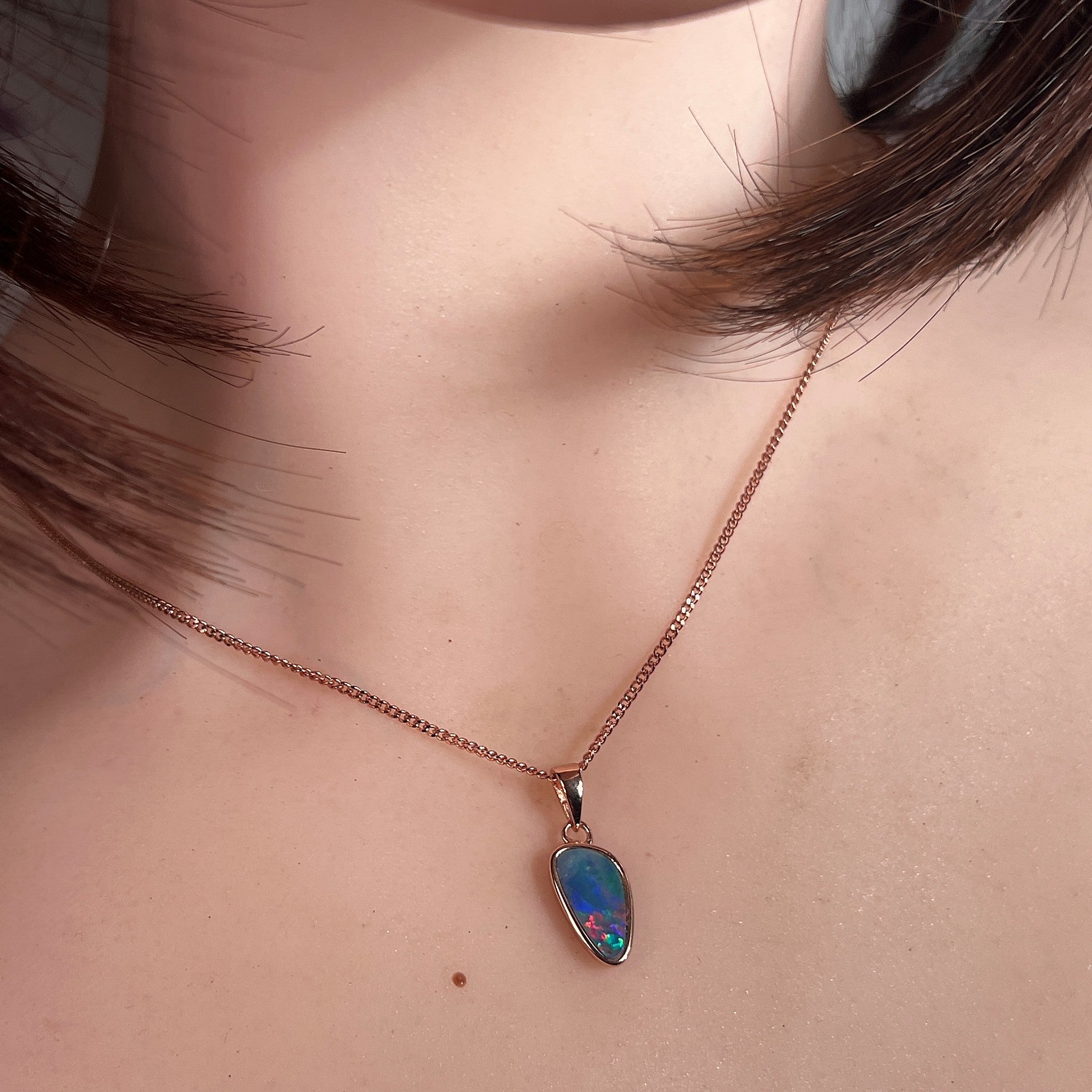 Worn Australian opal doublet pendant in rose gold-plated silver, red, green and blue, 12 x 6.5mm