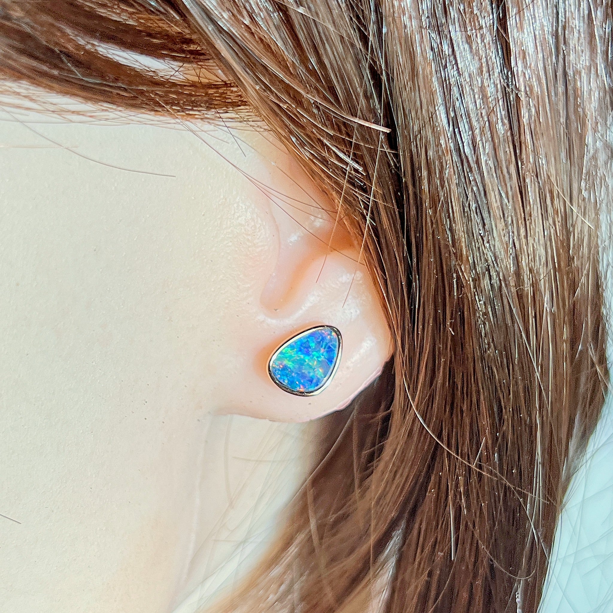 triangular Australian opal doublet earrings in rose gold-plated silver, worn on the ear