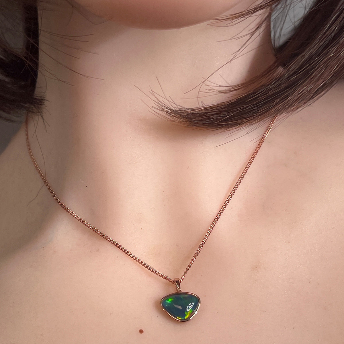 Worn Australian opal triplet pendant in rose gold-plated silver, red, blue, green and yellow, 9 x 11mm