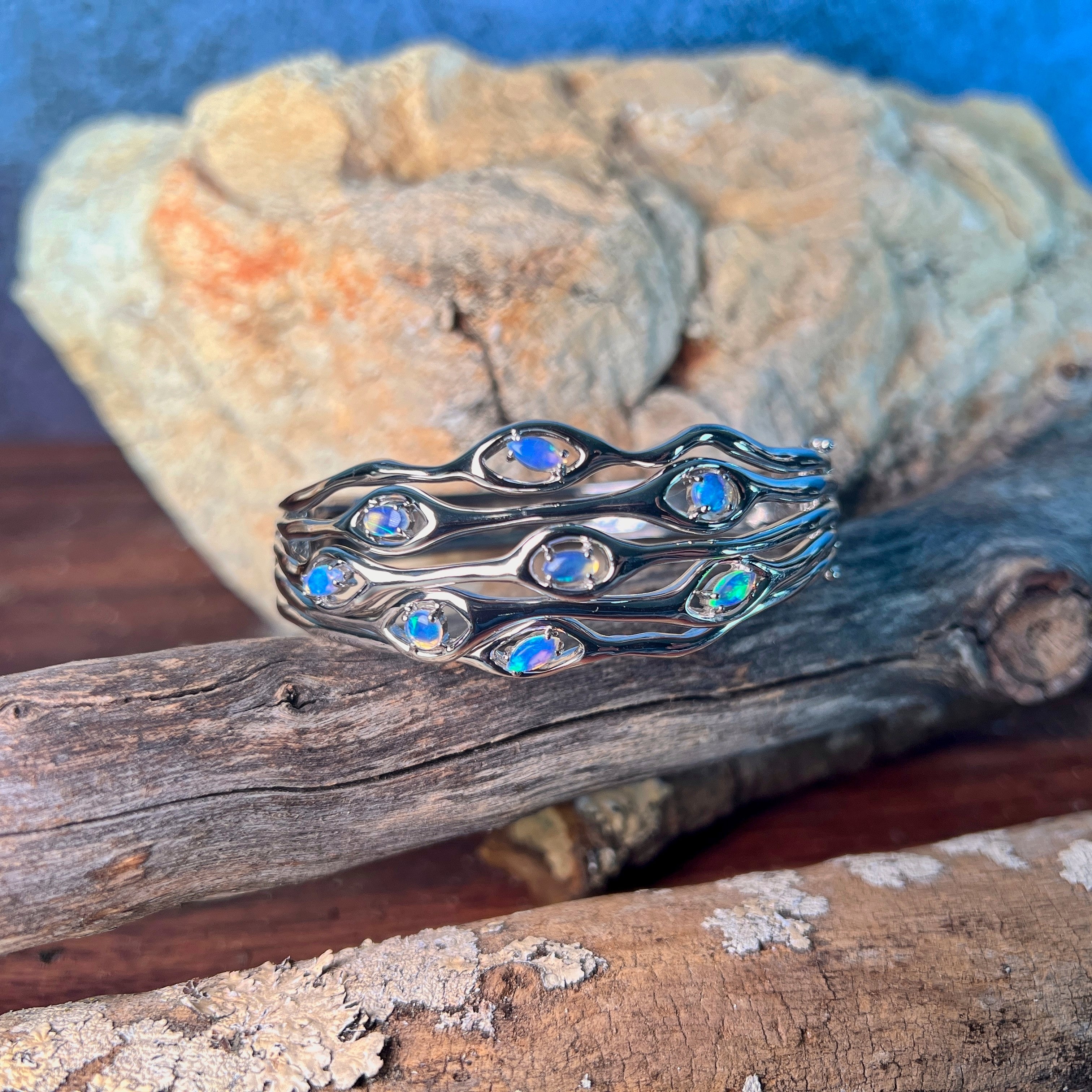 Sterling silver wave cut-out bangle set with 0.92ct of Australian opal