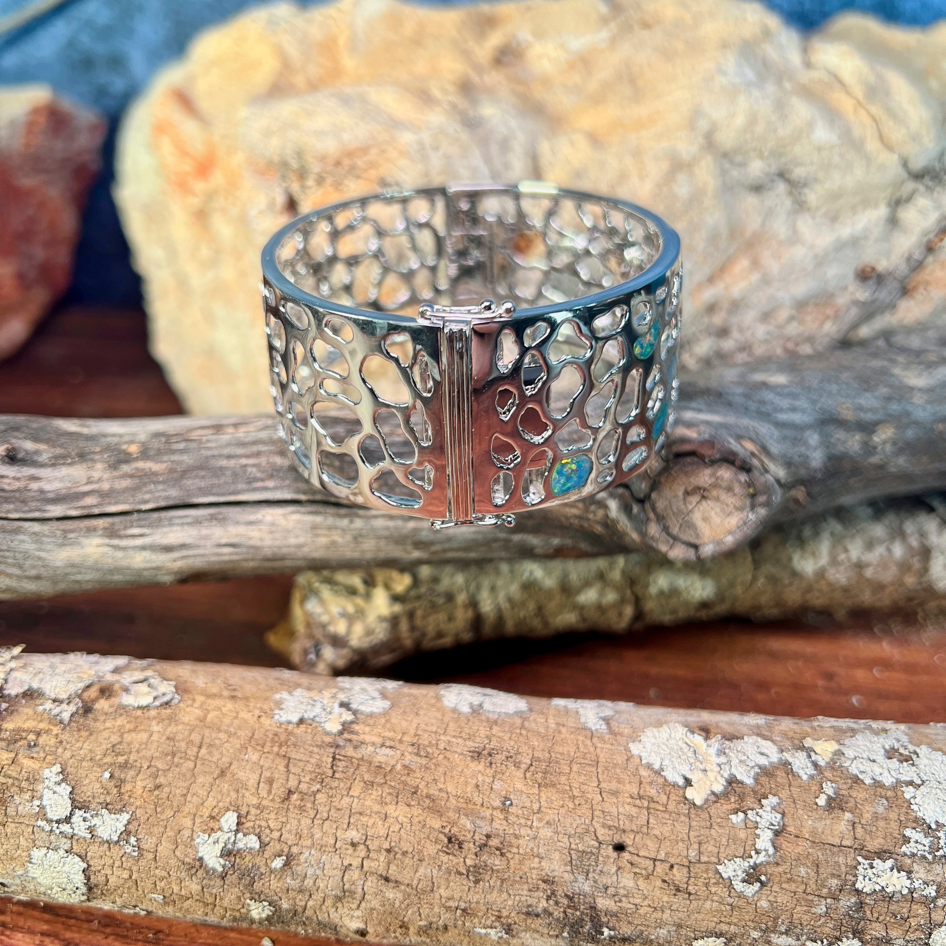 Sterling silver 26mm opal inlay bangle showing green and blue play-of-colour