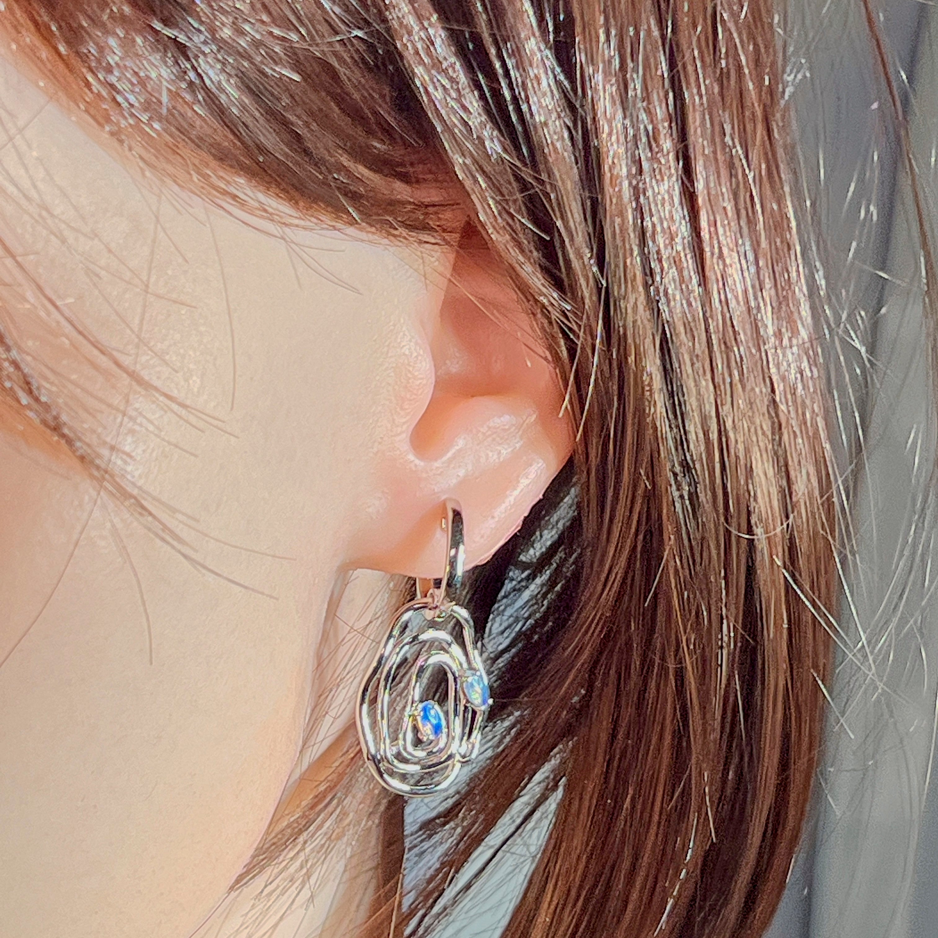 Sterling silver circle opal earring worn in the ear