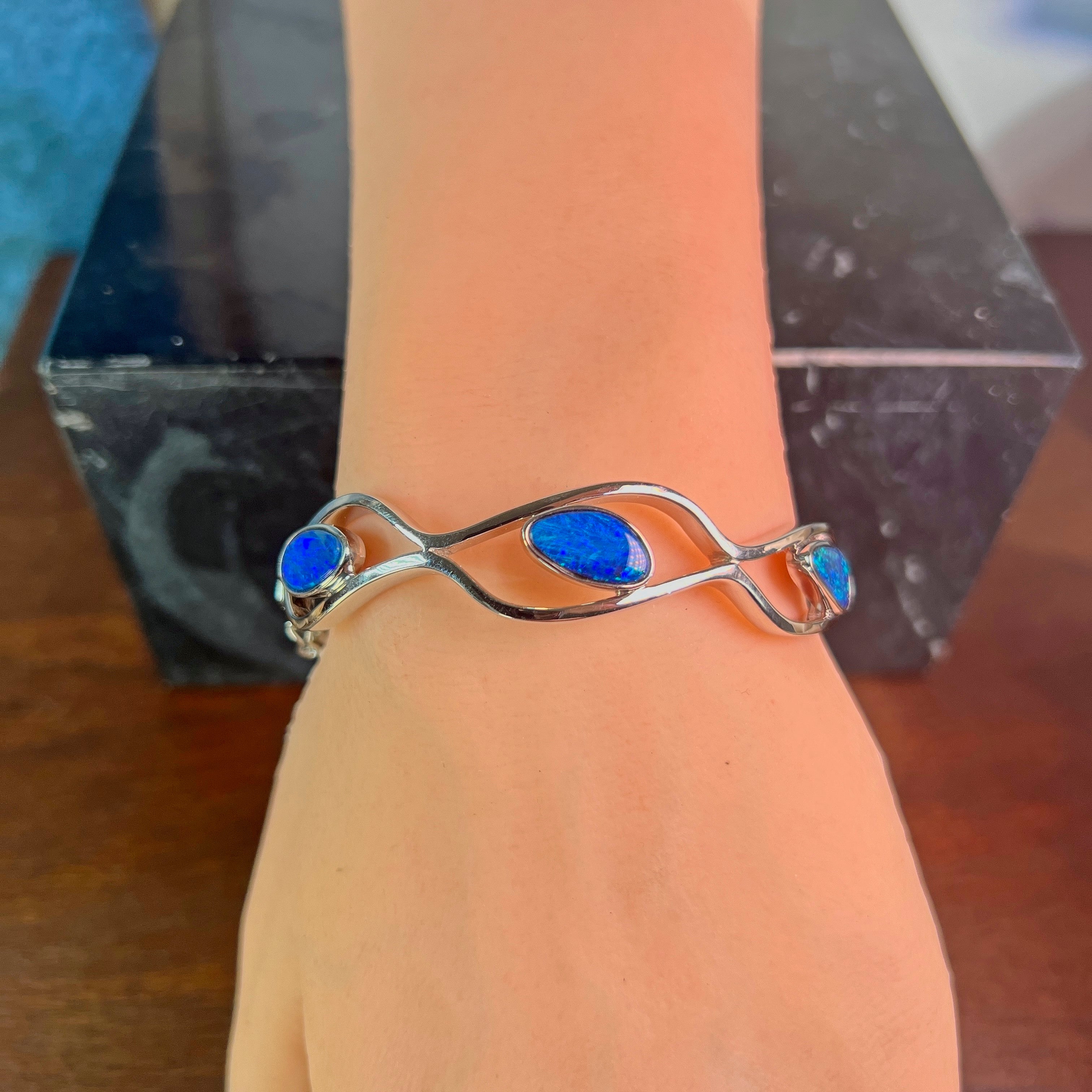 Sterling silver opal doublet wave bangle worn on the wrist
