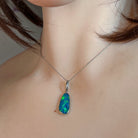 Green and blue opal doublet pendant in silver worn on a fine chain at the neckline